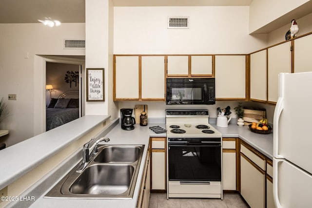 kitchen with range with electric cooktop, light tile patterned flooring, sink, white cabinets, and white fridge