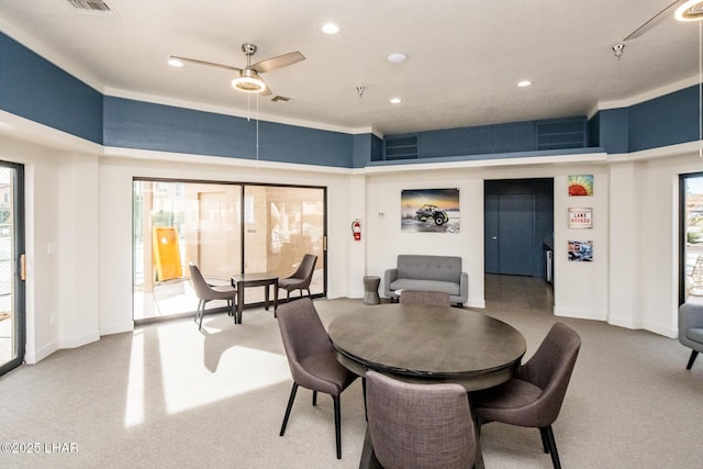 dining area featuring light carpet and ceiling fan