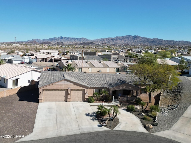 view of front of property with concrete driveway, a mountain view, an attached garage, and a residential view