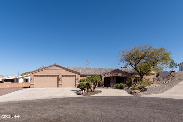 single story home with fence, a tiled roof, concrete driveway, stucco siding, and an attached garage