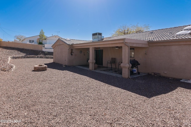 rear view of house featuring a patio, cooling unit, fence, stucco siding, and a tile roof