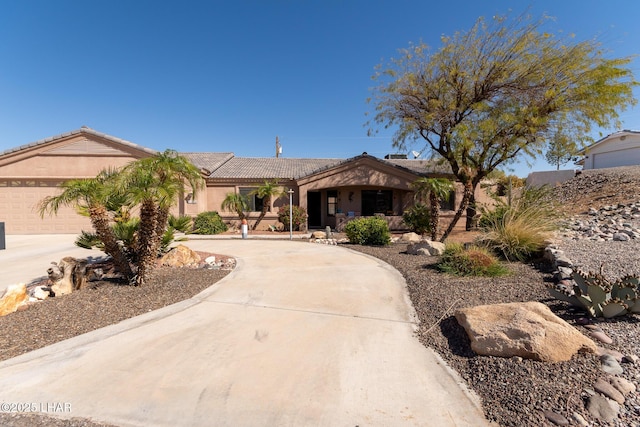 single story home with stucco siding, a garage, driveway, and a tile roof