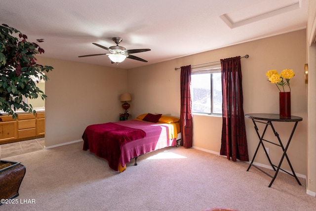 carpeted bedroom featuring ceiling fan, attic access, and baseboards