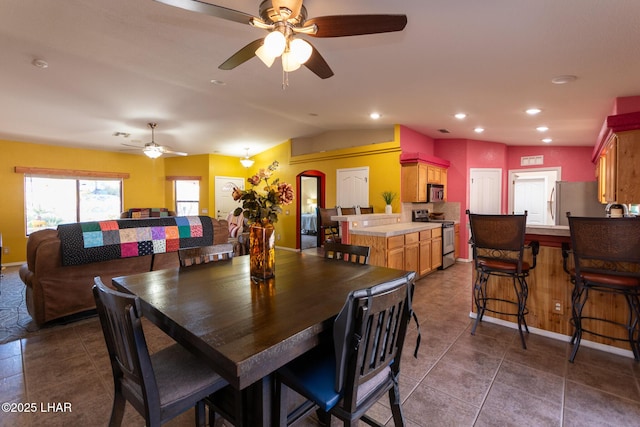 dining space featuring lofted ceiling, dark tile patterned flooring, and recessed lighting