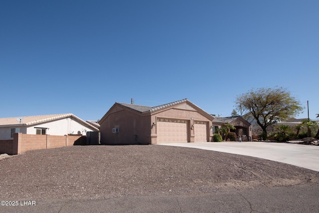 ranch-style home with fence, a garage, driveway, and stucco siding