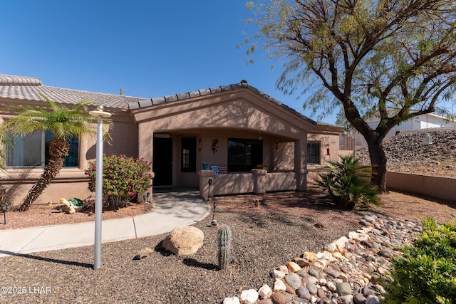 view of front of home with stucco siding and a tile roof