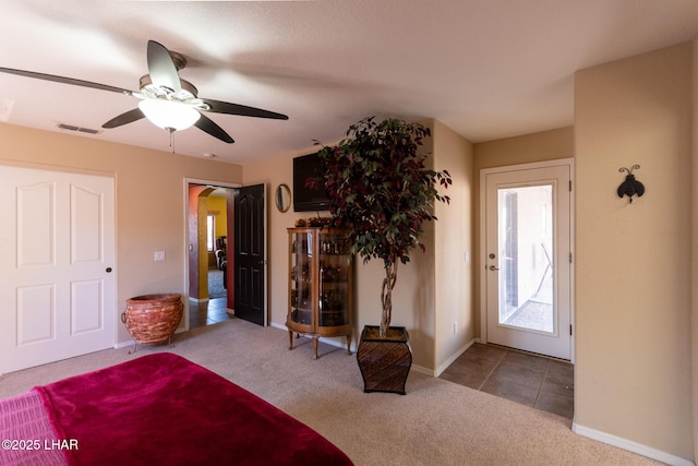 unfurnished bedroom with carpet flooring, baseboards, visible vents, and ceiling fan