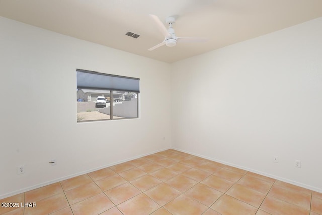 spare room with baseboards, a ceiling fan, visible vents, and light tile patterned floors