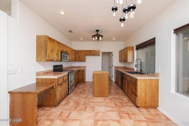 kitchen with visible vents, tile countertops, stainless steel appliances, and a sink