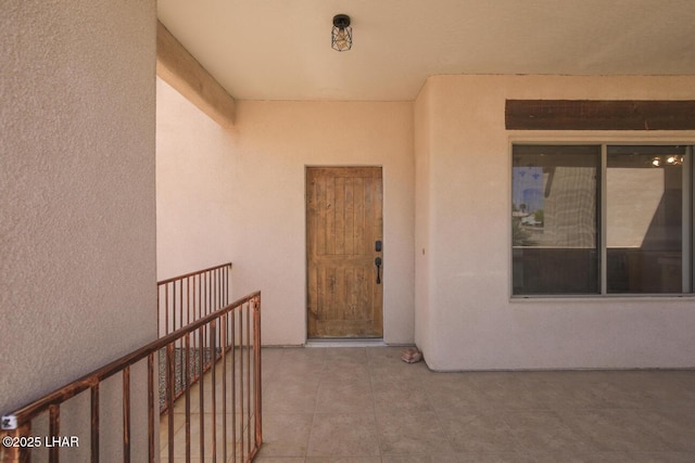 property entrance with a patio and stucco siding