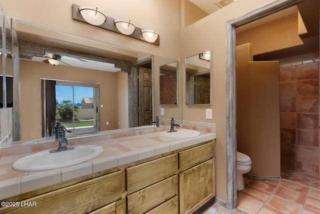 full bath featuring a ceiling fan, a sink, double vanity, and toilet