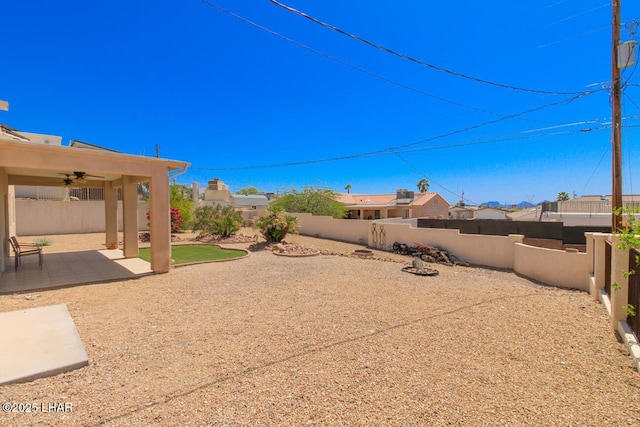 view of yard featuring a fenced backyard, a ceiling fan, and a patio