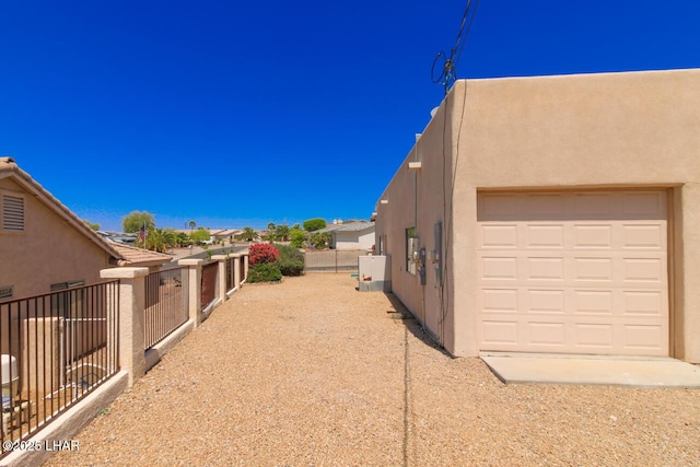 view of side of property with fence and stucco siding