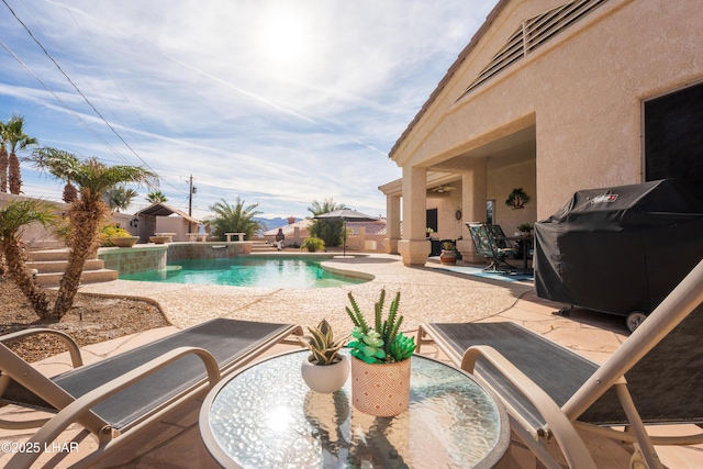 view of pool with a patio, pool water feature, and grilling area