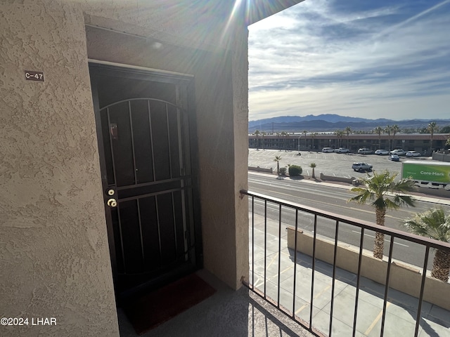 property entrance featuring a balcony, a mountain view, and stucco siding