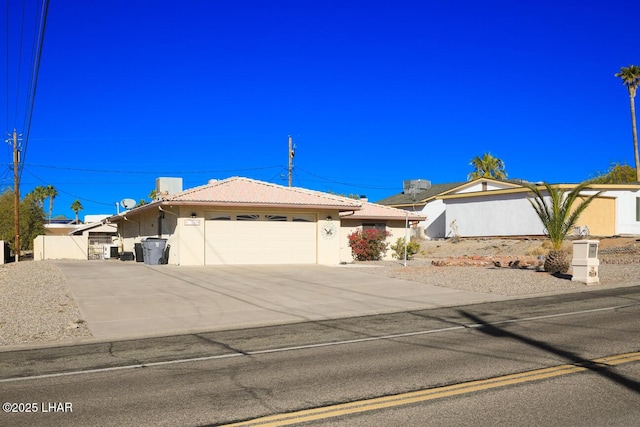 single story home featuring driveway, a tile roof, an attached garage, fence, and stucco siding