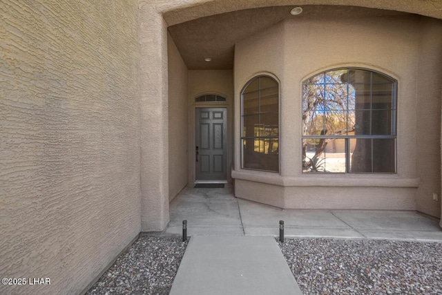 property entrance with stucco siding