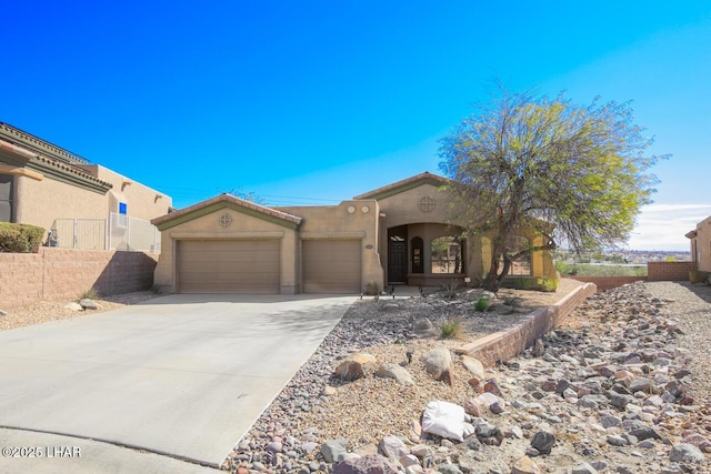 mediterranean / spanish home featuring concrete driveway, a tile roof, an attached garage, fence, and stucco siding