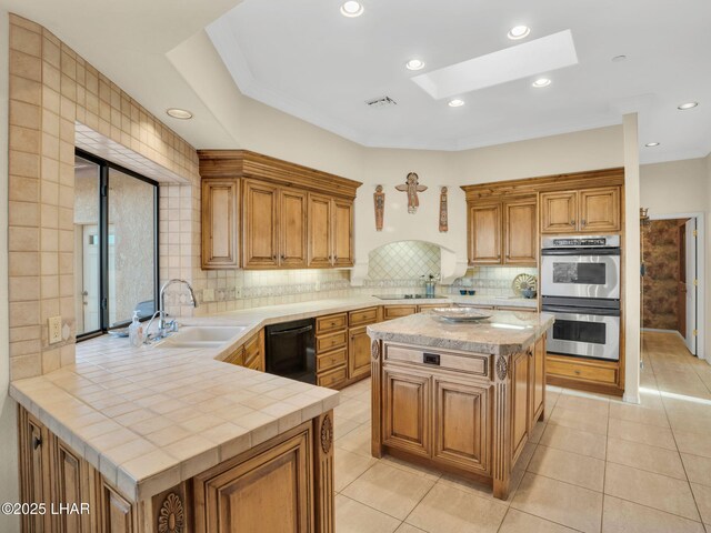 kitchen featuring a skylight, black dishwasher, kitchen peninsula, stainless steel double oven, and backsplash