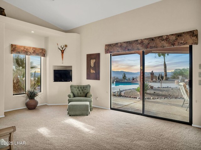 sitting room featuring vaulted ceiling and carpet