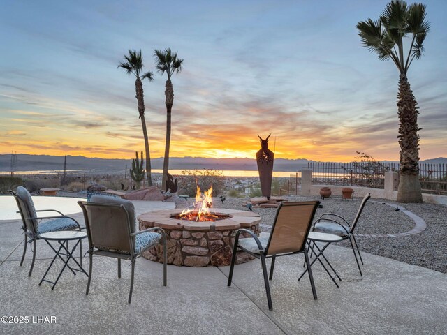 patio terrace at dusk with a mountain view and a fire pit