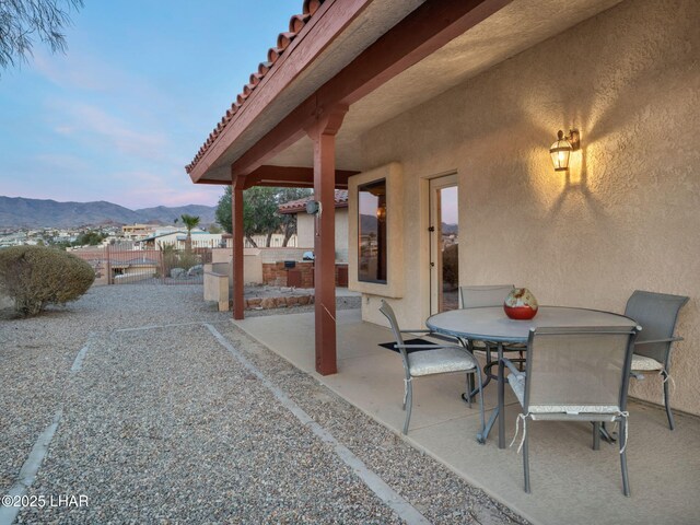 patio terrace at dusk featuring a mountain view