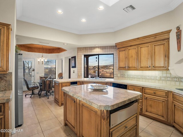 kitchen with backsplash, crown molding, hanging light fixtures, and a kitchen island