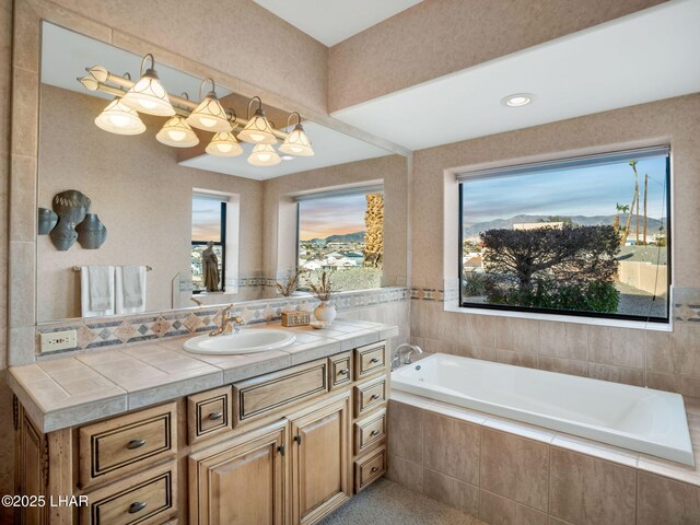 bathroom featuring vanity and a relaxing tiled tub