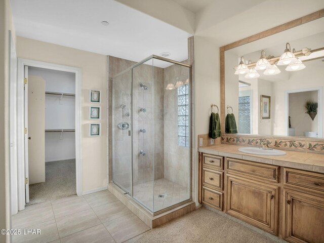 bathroom featuring tile patterned floors, vanity, and a shower with shower door