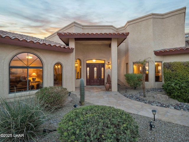 exterior entry at dusk featuring french doors