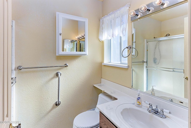 bathroom featuring vanity, an enclosed shower, and toilet