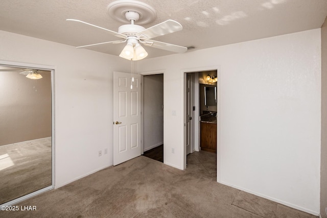 unfurnished bedroom with a textured ceiling, a closet, ceiling fan, and carpet