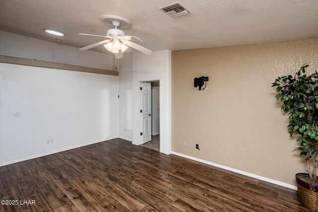 spare room with dark wood-type flooring and ceiling fan