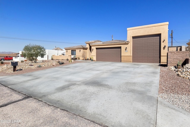 view of front of house featuring fence, a tiled roof, concrete driveway, stucco siding, and a garage