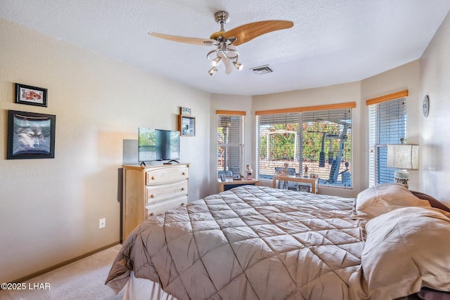 bedroom featuring visible vents, baseboards, a textured ceiling, a ceiling fan, and carpet