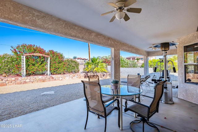 view of patio featuring fence, a ceiling fan, and outdoor dining area