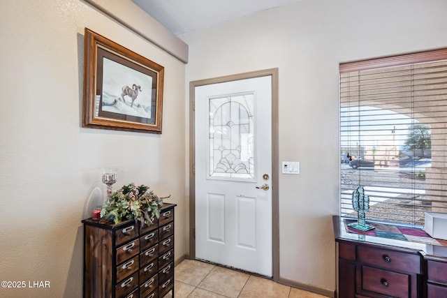 foyer entrance featuring light tile patterned floors and baseboards