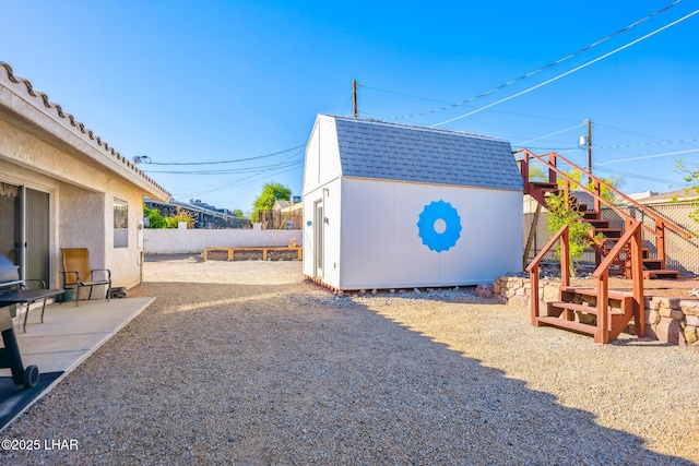 view of yard featuring an outdoor structure, a fenced backyard, and a storage unit