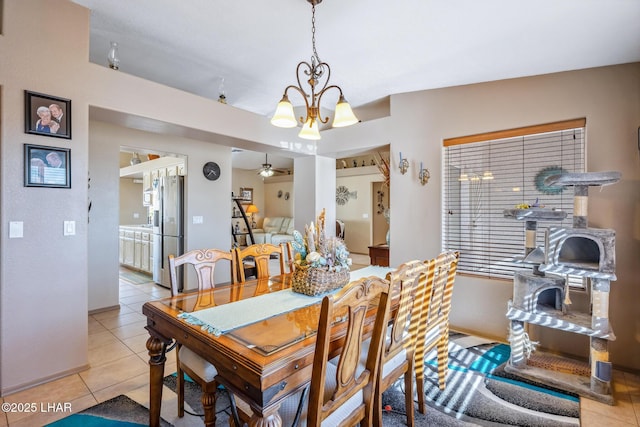 tiled dining area with baseboards and ceiling fan with notable chandelier