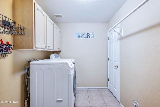 laundry room with cabinet space, light tile patterned flooring, baseboards, visible vents, and washing machine and dryer