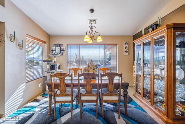 dining area featuring visible vents, carpet, and a notable chandelier