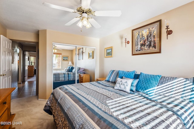 bedroom with light colored carpet, ceiling fan, and a closet
