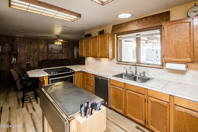 kitchen with stainless steel gas stove, sink, dishwasher, and light wood-type flooring