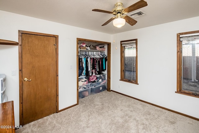 unfurnished bedroom with light carpet, a closet, and ceiling fan