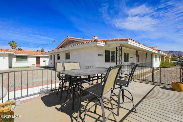 exterior space featuring outdoor dining space, a tile roof, and a patio