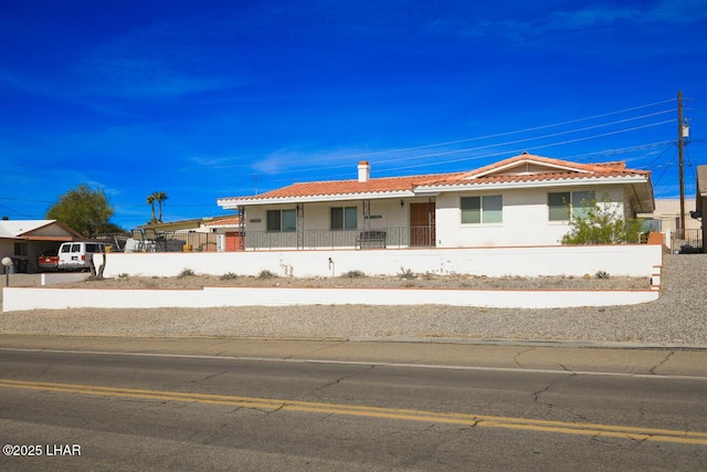 view of front of home featuring a tiled roof and a fenced front yard