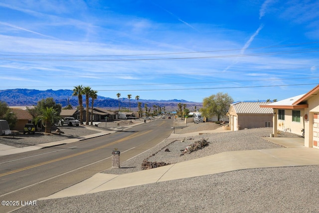 view of road featuring sidewalks and a mountain view