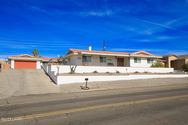 ranch-style home with a tiled roof, a fenced front yard, and stucco siding