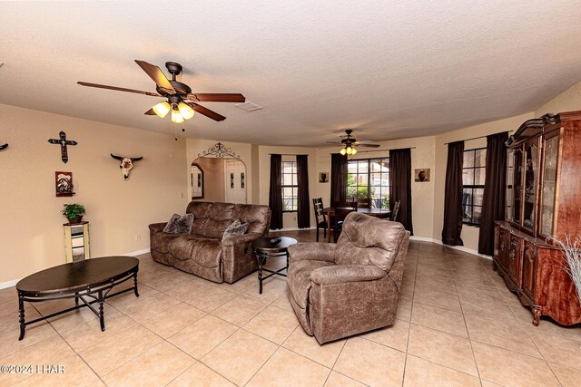 tiled living room featuring ceiling fan and a textured ceiling