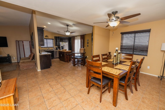 tiled dining area with plenty of natural light and ceiling fan